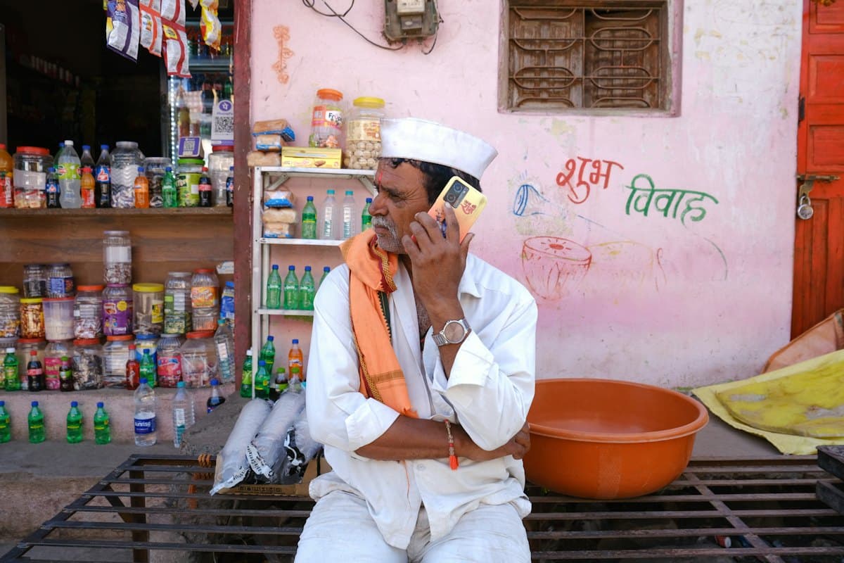 A shopkeeper on the phone outside his general store